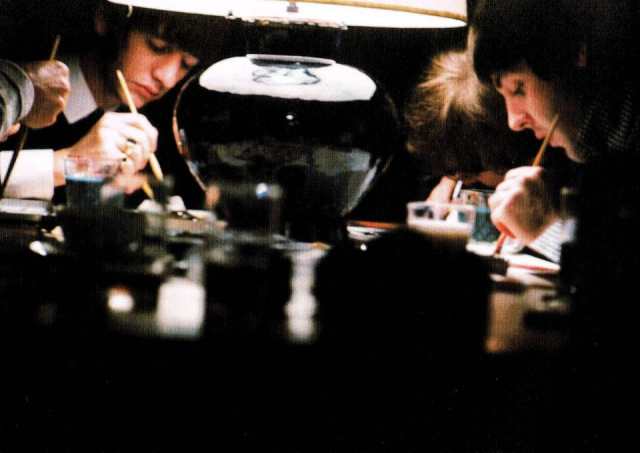 The Beatles painting a canvas with table lamp resting on it