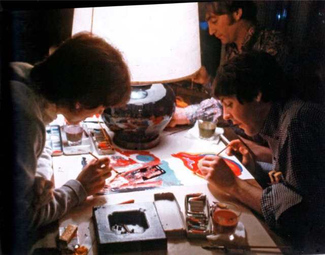 George Harrison, Paul McCartney, and John Lennon painting a canvas