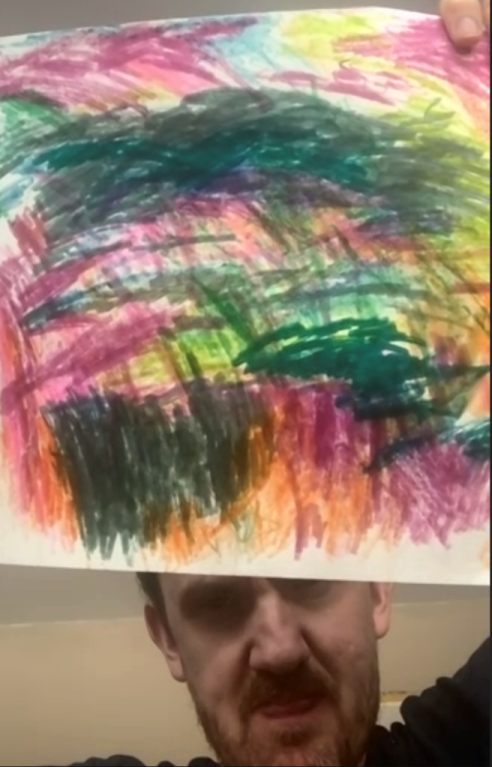 Tim Bridges holding up a piece of his colorful abstract art